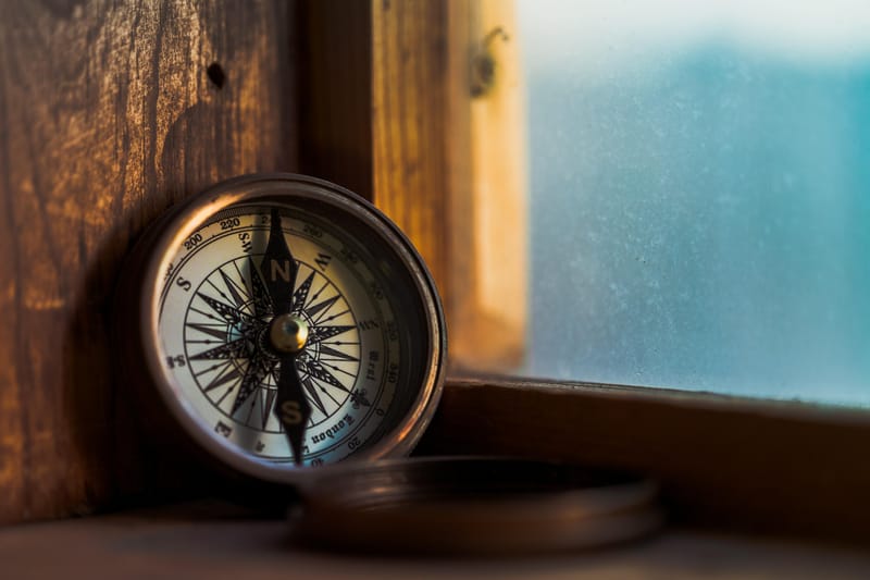 Compass sitting on a wooden windowsill