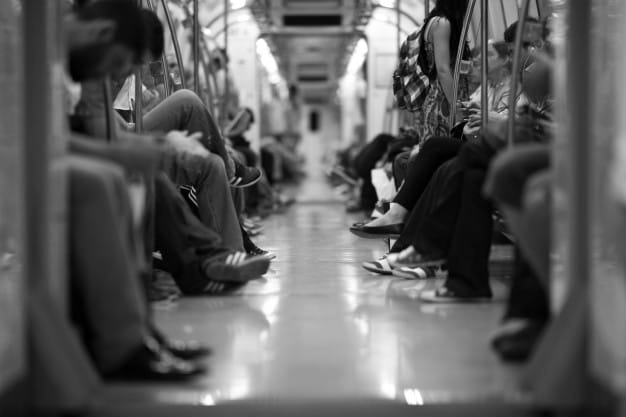 Black and white image of people sitting in subway